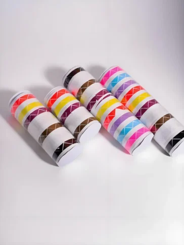 Several rolls of multi-colored photo corners arranged neatly.