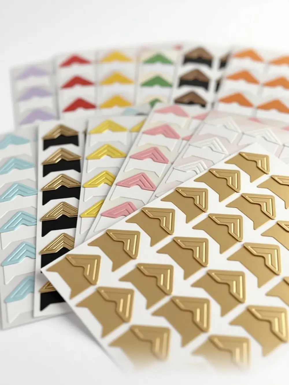 Bögen mit hochwertigen selbstklebenden Fotoecken in Gold, Schwarz und Weiß.