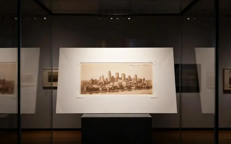 A priceless historical document securely mounted with archival photo corners inside a museum display case, showing a professional application.